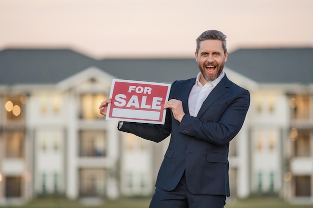 Photo handsome real estate agent holding banner house for sale house with land and insurance man real esta