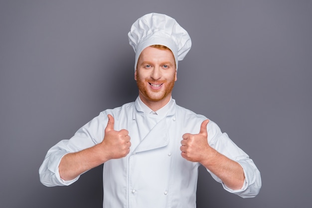 Handsome redhead chef posing against the grey wall