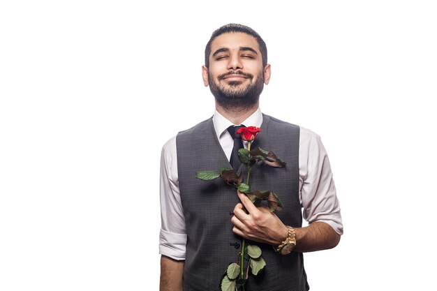 Photo handsome romantic happy man with rose flower. studio shot. isolated on white background. holding flower and closed eyes and feeling happiness..