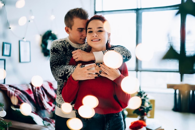 Uomo e donna romantici belli che si abbracciano in luci sfocate