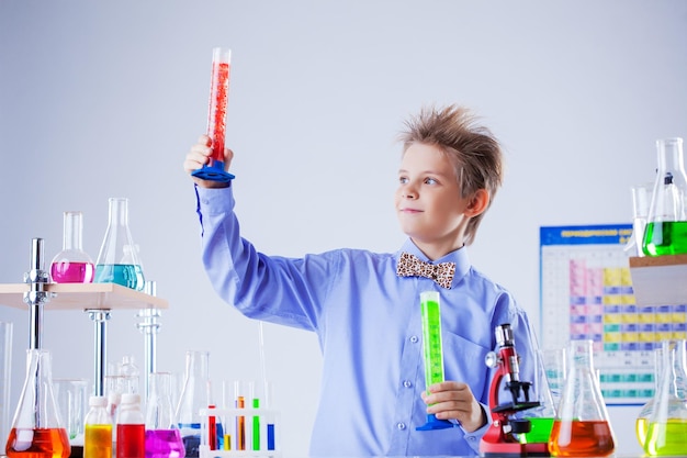 Handsome school boy posing with testtubes in lab