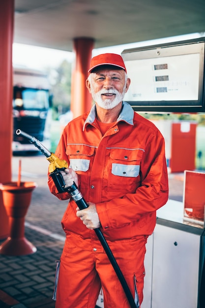 Handsome senior beard man working on gas station.