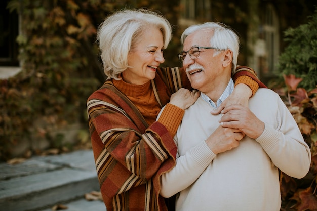 Handsome senior couple embracing in autumn park