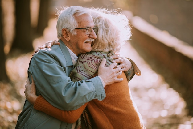 Handsome senior couple embracing in autumn park