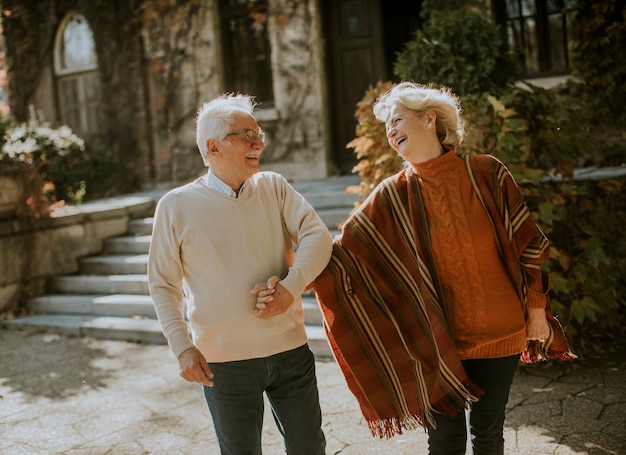 Handsome senior couple walking in autumn park