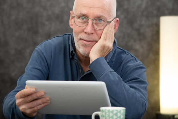 Handsome senior man using tablet computer