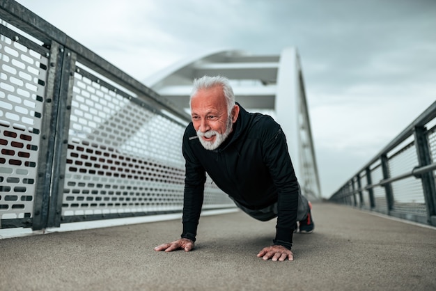 Photo handsome senior sportsman doing push-ups.