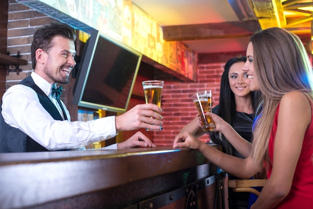 Handsome smiley bartender stretching out beer.