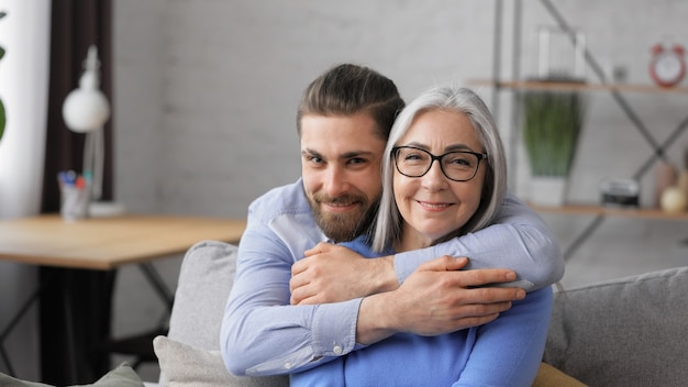 Uomo adulto sorridente bello che abbraccia bella madre matura senior.