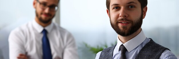 Handsome smiling bearded clerk man at workplace look in camera