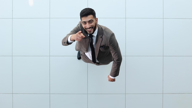 Handsome smiling business man in a suit standing with his arms crossed