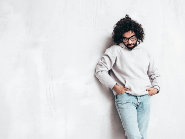 Handsome smiling hipster man posing in studio