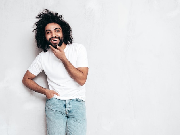 Handsome smiling hipster man posing in studio