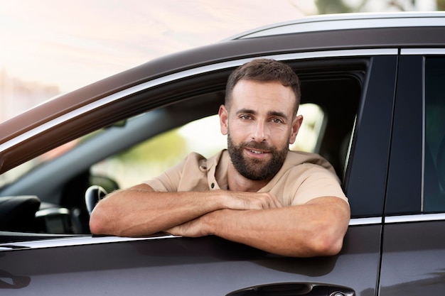 Handsome smiling latin driving sitting in car looking at camera. Transportation concept