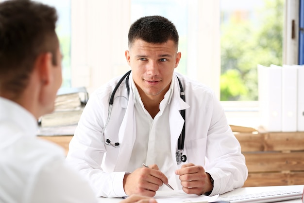 Handsome smiling male doctor hold silver pen