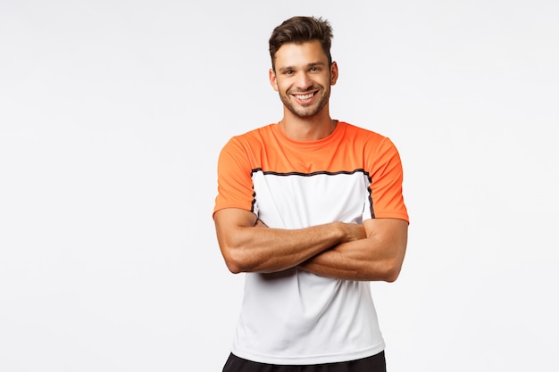 Handsome smiling man bodybuilder, cross arms over chest, wear sport t-shirt.