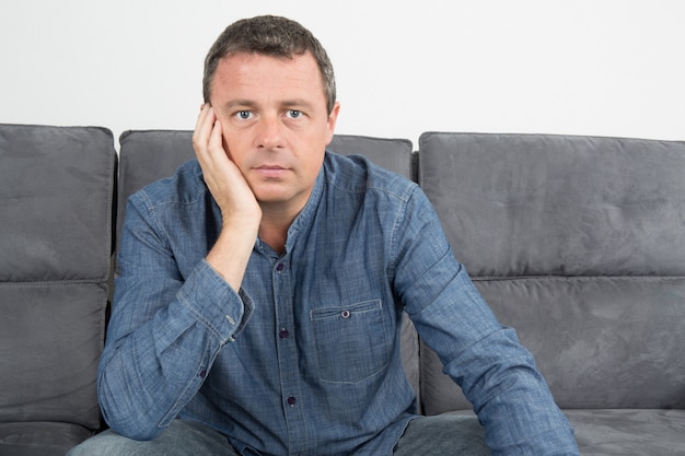 Handsome and smiling man sitting in couch