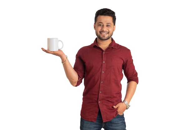 Красивый улыбающийся мужчина с чашкой кофе или чая на белом фоне