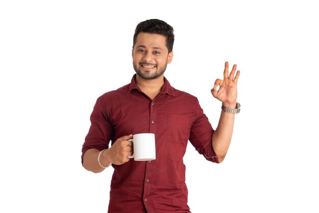 Handsome smiling man with cup of coffee or tea isolated on white background