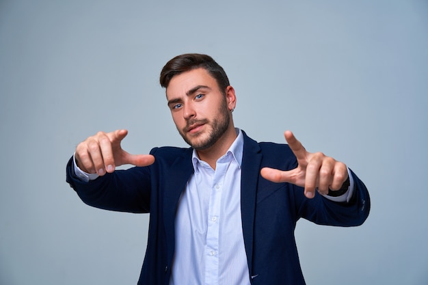 Handsome smiling young businessman on gray background