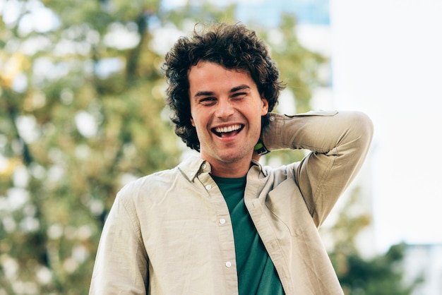 Handsome smiling young man posing for advertisement and looking at the camera Portrait of smart male has joyful expression