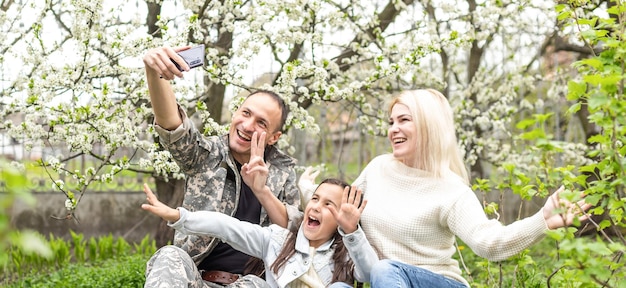 Handsome soldier reunited with family on a sunny day.