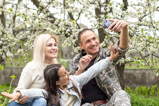 Handsome soldier reunited with family on a sunny day.