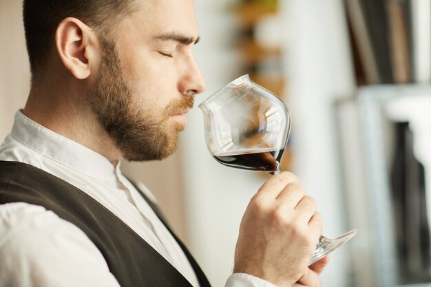 Sommelier bello che sente l'odore del vino