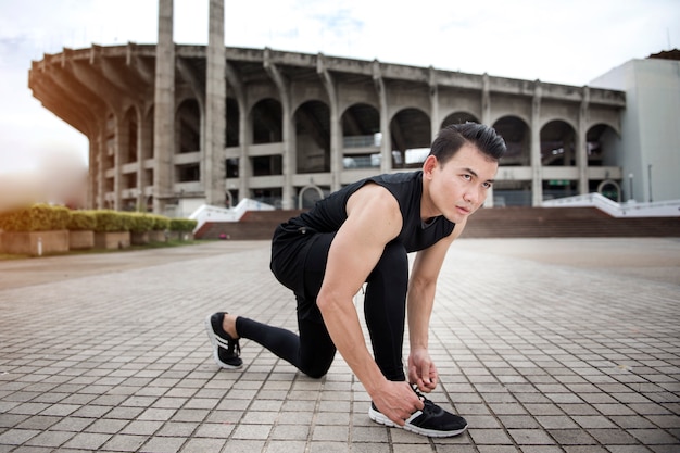 屋外の都市で運動するハンサムなスポーツマン