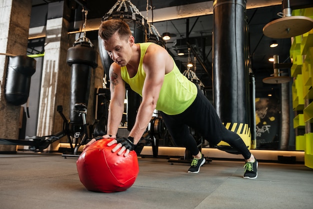 Lo sportivo bello fa gli esercizi di sport in palestra