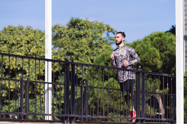 Handsome sportsman running around the city