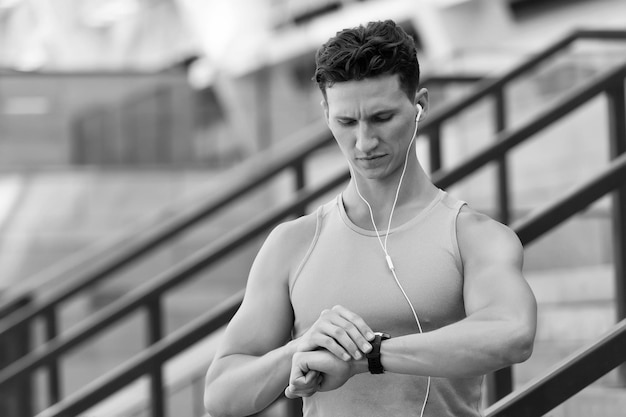 Handsome sportsman set up fitness application with smart watch