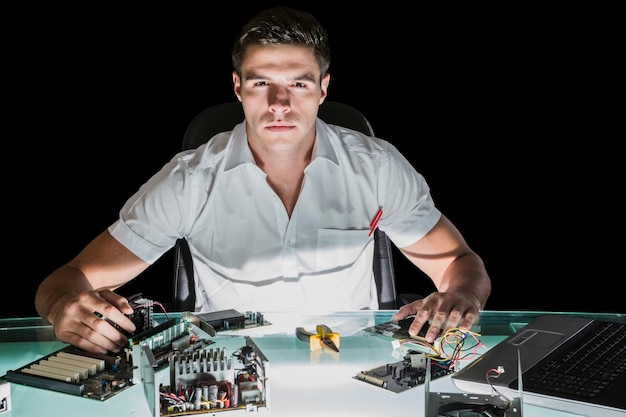 Handsome stern computer engineer working by night