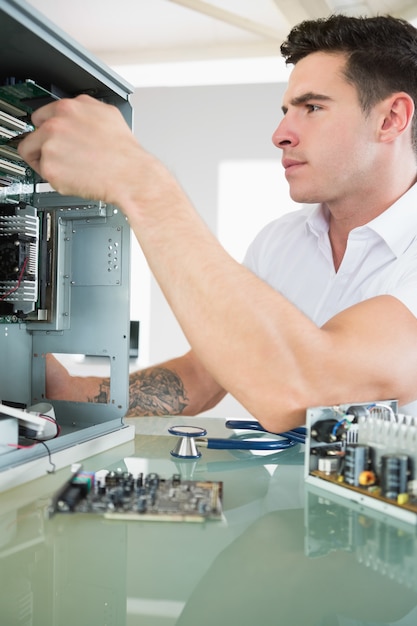 Handsome stern computer engineer working at open computer