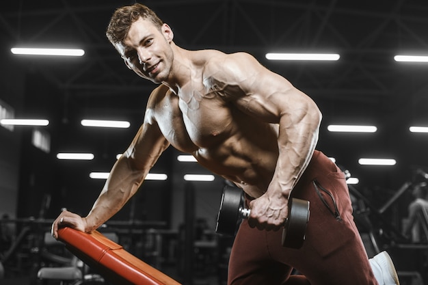 Foto uomini atletici forti belli che pompano il bodybuilding di allenamento dei muscoli