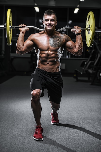 Handsome strong bodybuilder athletic men pumping up muscles with dumbbells