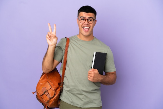 Handsome student man over isolated background smiling and showing victory sign