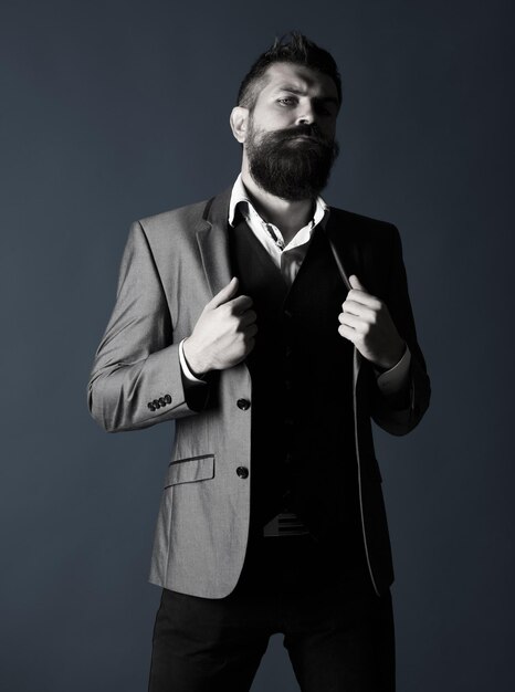 Uomo barbuto alla moda bello. ritratto in studio di un uomo hipster barbuto. barba e baffi maschili. uomo barbuto in giacca e cravatta. bellezza maschile, moda. maschio sexy, macho, barba lunga. bianco e nero.