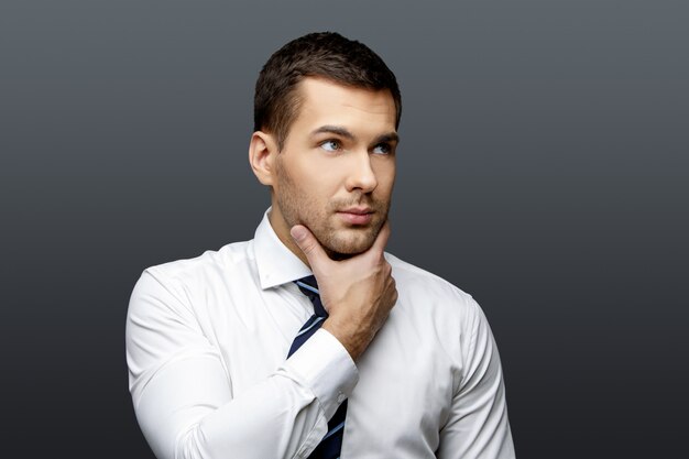 Handsome stylish businessman on grey background