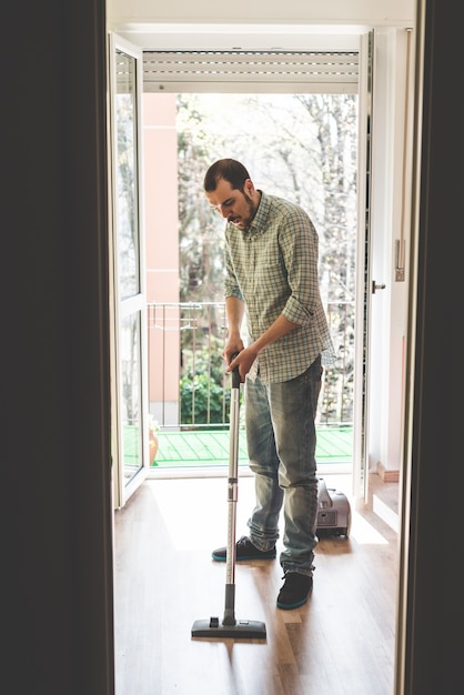 handsome stylish man using hoover