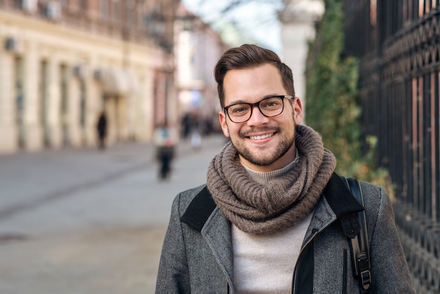 写真 カメラを見て、街で冬の日にハンサムなスタイリッシュな若い男。