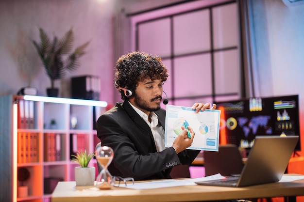 Photo handsome successful qualified bearded office manager in suit wears headset during online video call