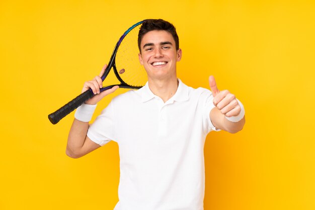 Handsome teenager tennis player man isolated on yellow