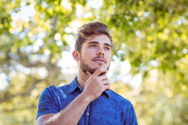 Handsome thinking hipster in the park