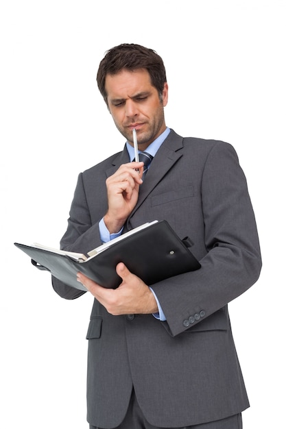 Handsome thoughtful businessman holding his diary