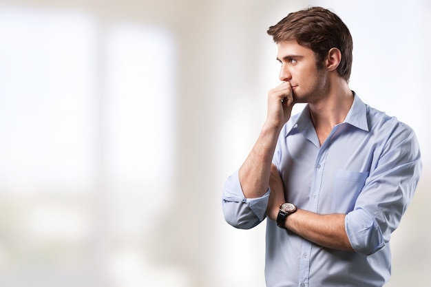 Handsome thoughtful young man on bright background