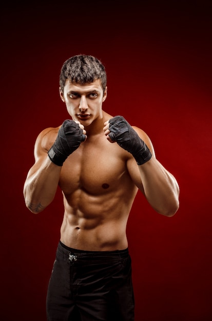 Handsome topless muscular man in fighting gloves