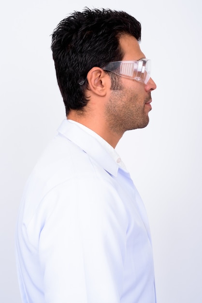  handsome Turkish man doctor wearing protective glasses against white wall