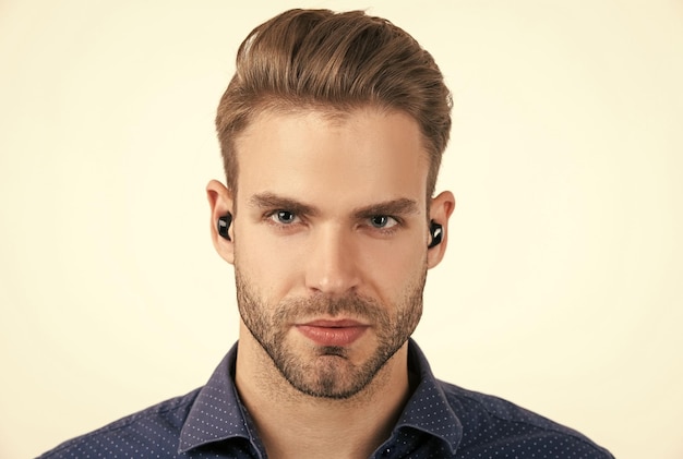 Handsome unshaven man with wireless bluetooth earphones isolated on white bluetooth headset