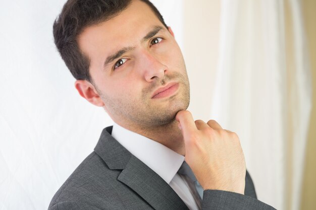 Handsome unsmiling businessman posing at camera